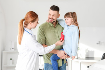 Man with his little daughter visiting gastroenterologist in clinic