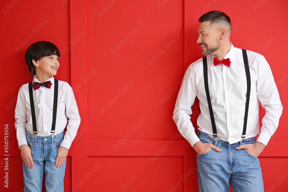 Sticker stylish father and little son on color background