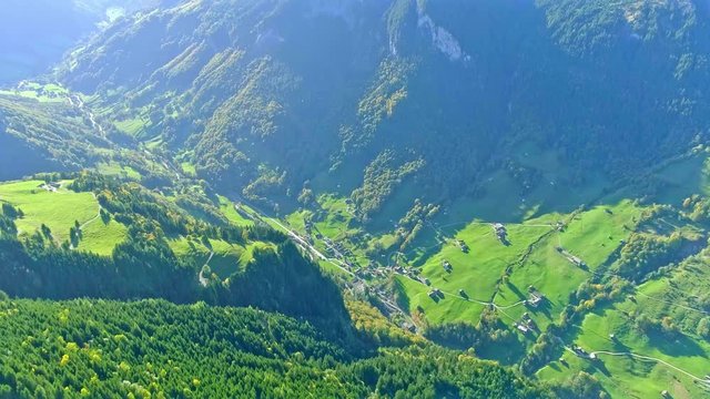 Aerial view of the valley between the mountains covered with the green forest