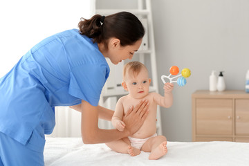 Obraz na płótnie Canvas Massage therapist working with cute baby in medical center