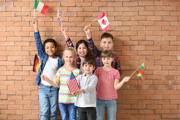 Little pupils of language school on brick background