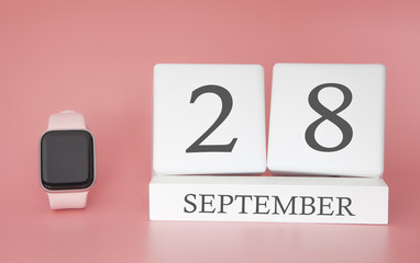 Modern Watch with cube calendar and date 28 september on pink background. Concept autumn time vacation.