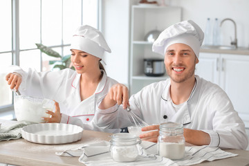 Young confectioners cooking tasty dessert in kitchen