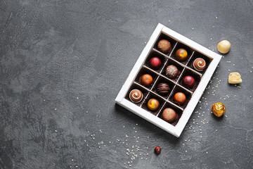 Box with delicious candies on dark background