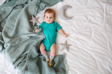 Cute little baby lying on bed, top view