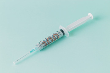 One hundred US dollars inside of a medical syringe on a green background