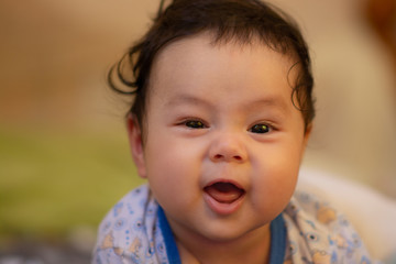 Happy baby boy  playing  on bed