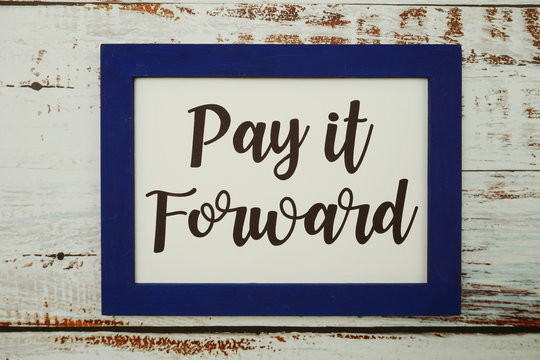 Pay It Forward Written With Blue Photo Frame Flat Lay On Wooden Background