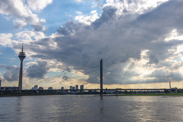 Image of a Tower and Suspension Bridge beside a river during cloudy summer weather in Germany