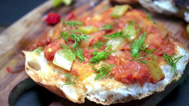 Panning on brushetta with colorful toppings on it.