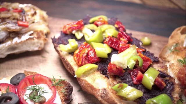 Brushettas with colorful toppings on blurry wooden background.