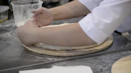 Cook's hands knead the dough.