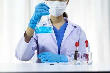 Fototapeta premium Scientist holding Coronavirus covid-19 infected blood sample tube DNA testing of the blood in the laboratory with blood sample collection tubes and syringe Coronavirus Covid-19 vaccine research.