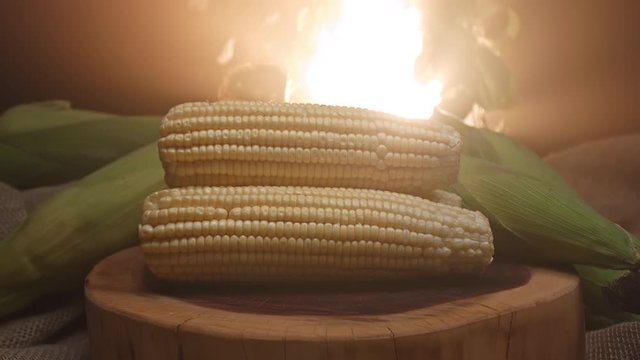 Three corns stacked on top of a wooden board