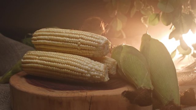 Three corns stacked on top of a wooden board