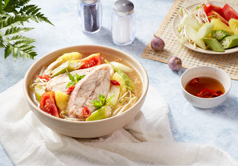 Vietnam food traditional. Snakehead fish sour soup, ingredient around the main dish with blue light paint brush texture background	