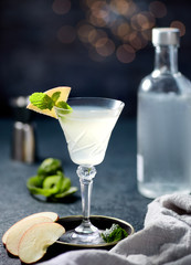 Alcoholic cocktail with apple, mint in holiday. Dark mood, side view