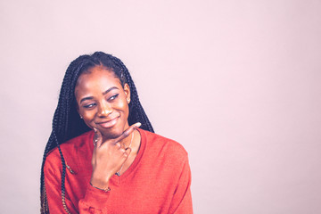 X Happy, positive African American female in red color shirt on gray background. 