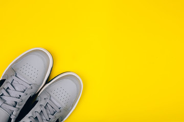 Stylish gray sneakers on a yellow background, healthy lifestyle, jogging, sports shoe store