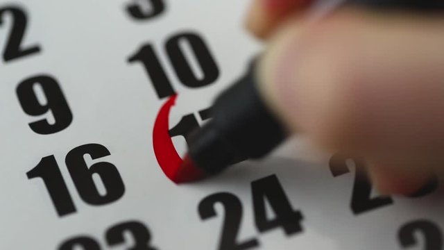 Mark the 17th day of the month on the calendar in red pencil. A female hand draws a circle on the calendar around figure 17. The date of the event, an important day of the month.