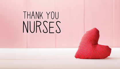 Thank You Nurses message with a red heart cushion over a pink wooden wall
