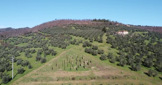 Agricultural fields form geometrical shapes. Aerial backward. Tuscany hills around Sieci Pontassieve, Chianti area of Frescobaldi, Italy