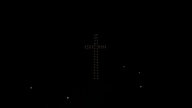 Coron sign and cross illuminated on top of Mt. Tapyas at night in Coron City Busuanga Island Philippines, aerial dolly out reveal shot