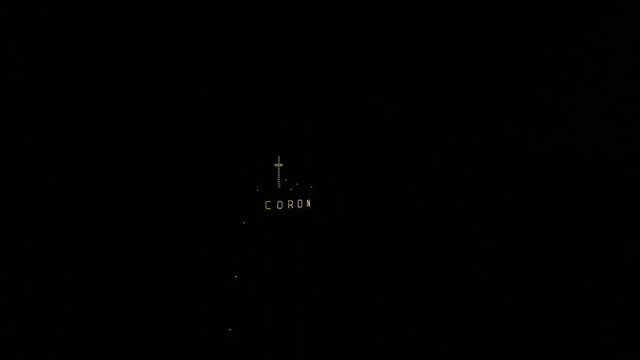 Illuminated Coron City sign and cross monument at Mt. Tapyas during night Busuanga Island Philippines, aerial approach shot