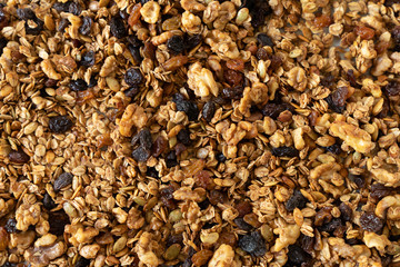 Healthy granola cereal with oats, pumpkin seeds, walnuts, and raisins, top view