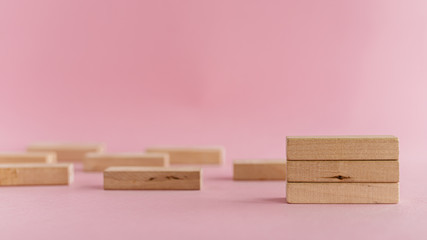 Wooden toys arranged on pink background for leisure activities concept