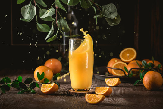 Fresh orange juice with fresh fruits on dark background