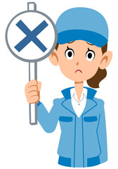 不正解の札を出す青い作業着を着た女性の上半身
