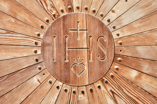 IHS, Kreuz, Herz, Buchstaben, Christus, Christusmonogramm, Monogramm, Holz, Holzt&uuml;r, Schnitzerei, geschnitzt, Verzierung, Glaube, Religion, Christentum, Nomen sacrum, Symbol, Zeichen, Andacht, Gebet, 