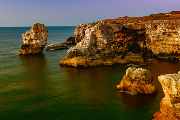 Fototapeta na wymiar admiring the sunset on the rocks by the sea