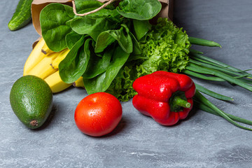 Different food in paper bag on wooden background, close up.