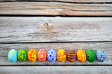 Colorful easter eggs on wooden rustic table.