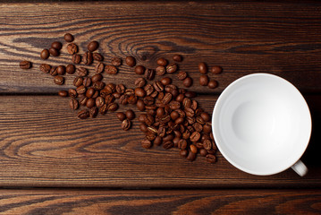 Coffee cup and coffee beans on wooden background. Top view.