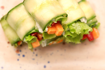 Plate with tasty cucumber rolls, closeup