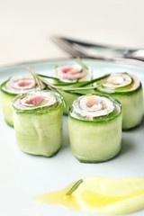 Plate with tasty cucumber rolls, closeup
