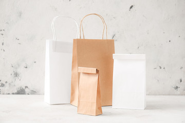 Paper bags on table against light background