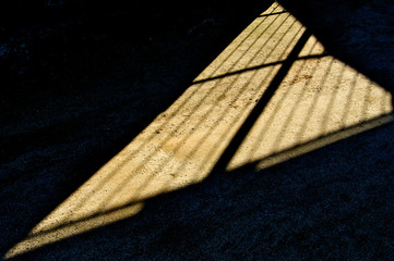 Shadow cast by bars onto dirt floor