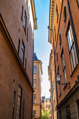 Fototapeta na wymiar Beautiful, Traditional Swedish Buildings Line a Narrow Alley in the Gamla Stan Neighborhood of Stockholm, Sweden