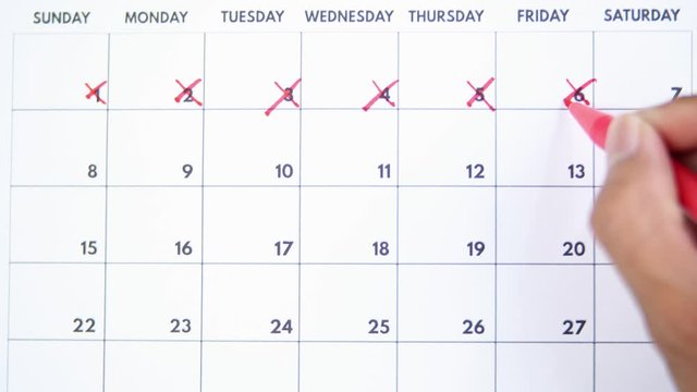 Male hands crossing out numbers in a calendar