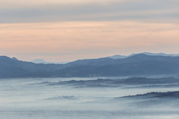 Fog filling a valley in Umbria (Italy) at dawn, with layers of mountains and hills