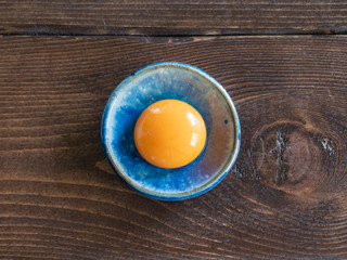青いお皿に映えるオレンジ色の新鮮な卵黄。