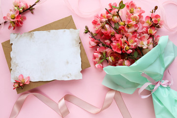 greeting card mockup. invitation card. bouquet of spring bouquet and an envelope on a pink background. space for text. wedding invitation