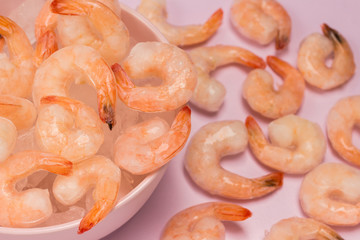 Tails of frozen shrimp in bowl.