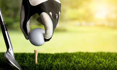 Hand of golfer putting golf ball on the tee.