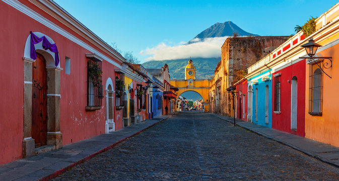Panorama Sunrise in the Main Street of Antigua City with the Santa Catalina Arch and Agua Volcano, Guatemala.