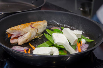 Chef preparing dishes in a frying pan